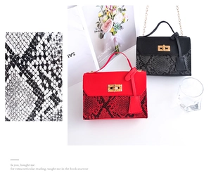 Detailed view of snake skin texture and golden twist lock on stylish leather handbags