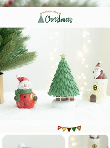 Close-up of Santa Claus and snowman figurines in a snowy Christmas scene display