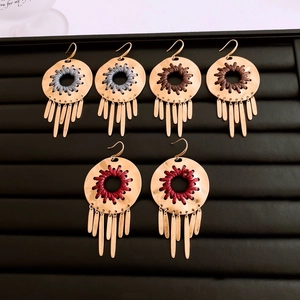 Detailed view of bohemian alloy tassel earrings in grey, brown and red woven styles