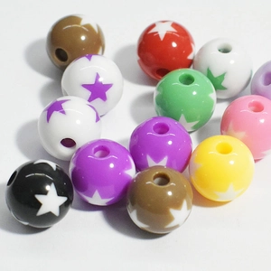 Close-up of assorted colorful acrylic beads with star patterns and holes for jewelry making