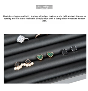Detail view of black PU leather jewelry tray with grooves for rings and earrings