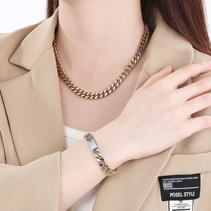 Gros plan d'un ensemble collier et bracelet gourmette bicolore or et argent sur mannequin