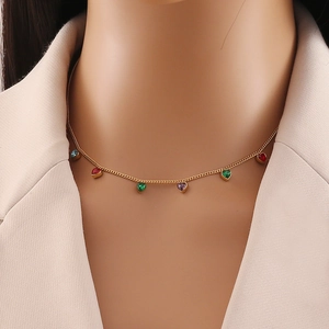 Close-up of golden necklace with colorful heart-shaped crystal pendants on a model