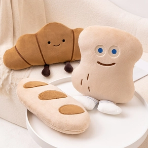 Coussins en peluche pain avec croissant et baguette sur un canapé beige doux