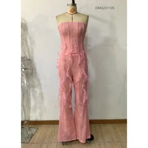 Détail du tissu en dentelle florale rose avec volants sur le pantalon évasé