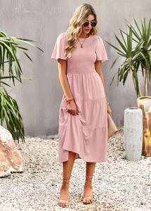 Detail of the pink short-sleeved dress showing waist-slimming smocked bodice craftsmanship
