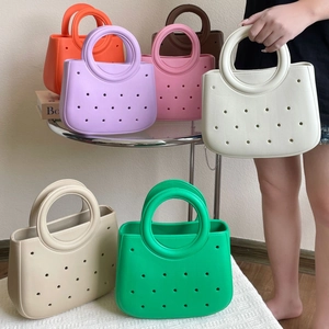 Gros plan sur les sacs de plage mini en EVA de couleurs blanc orange violet et autres