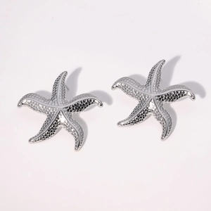 Boucles d'oreilles étoiles de mer argentées avec texture métallique sur fond blanc