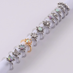 Macro view of sunflower-shaped septum rings with opal and diamond-like stones