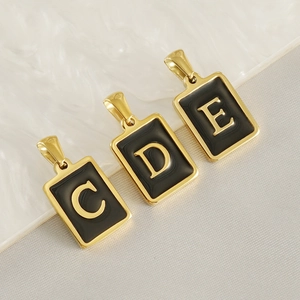 Detail of rectangular 18K gold plated pendants with black enamel and letters C D E