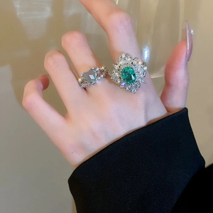 Close-up of double-layer ring set featuring emerald cut green stone and blue heart zircon