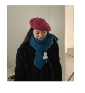 Detail of teal chunky knit scarf with vertical texture and stylish pink beret hat