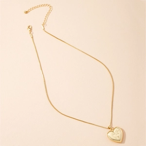 Vintage gold heart locket necklace with intricate floral engraving on a fine chain
