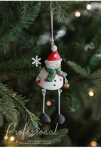 Charming hand-painted snowman ornament with red hat hanging on a festive Christmas tree