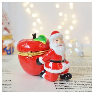 Close-up of a Santa Claus ceramic jewelry box with red apple and gold hinge detail