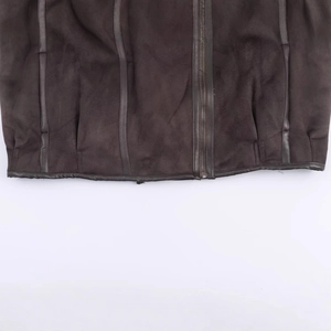 Detail shot of a dark brown suede jacket hem showing thick fabric and metal zipper