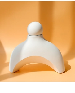 Detailopname van de minimalistische witte keramische nekmassager met gladde matte afwerking