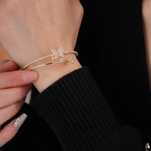 Detailed view of a gold double-layer zircon butterfly and clover open cuff bracelet