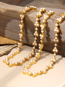 Detailed view of vintage gold-plated pearl necklace on rustic wood and antique paper background