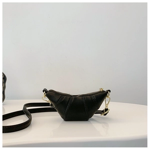 Detail of black leather croissant crossbody bag with golden zipper and textured finish