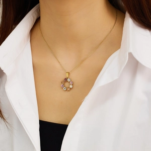 Primer plano de collar de titanio dorado con colgante de corazón de circón de colores en modelo