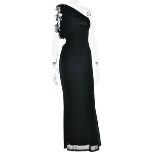 Détail d'une robe noire asymétrique avec fleurs à volants et ourlet en tulle transparent