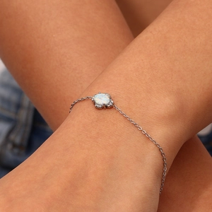 Makro-Detail eines Silberarmbands mit ovalem weißem Opal und Zirkon-Akzenten