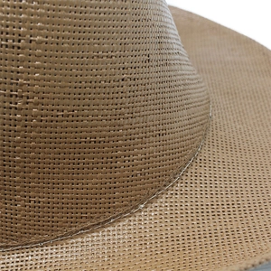 Close-up of tight plain weave texture and durable stitching on a brown cowboy straw hat