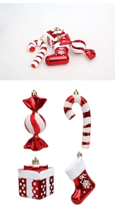 Close-up of red and white glitter Christmas candy cane, boot, and gift box ornaments