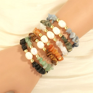 Detailed shot of multi-colored natural stone and freshwater pearl elastic bracelets on wrist