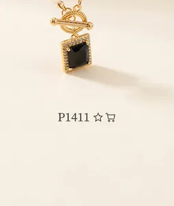 Detail of gold necklace with black square stone pendant and sparkling zircon border