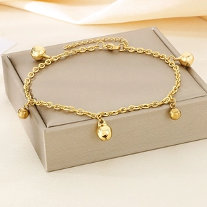 Bracelet de cheville doré en acier inoxydable avec cinq grelots sur support bijoux