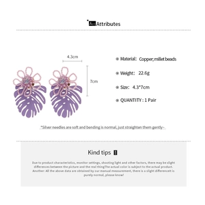 Detail showing dimensions of handmade bead flower and leaf earrings on white background