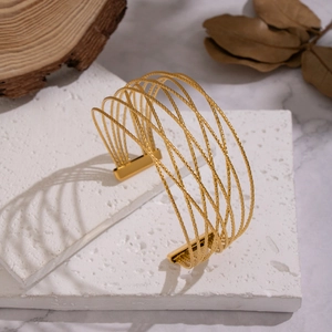 Minimalist multi-layer gold twisted wire cuff bracelet on a natural stone base