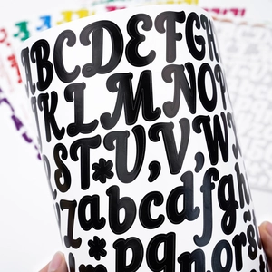 Gros plan d'autocollants alphabet noir avec lettres rondes sur vinyle brillant de qualité