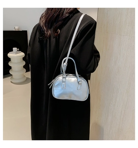Detail of silver metallic mini Boston bag with shiny leather texture and long shoulder strap