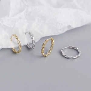 Macro shot of gold and silver chain link hoop earrings with sparkling cubic zirconia