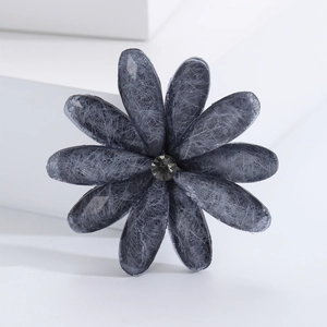 Detailed close-up of a charcoal grey acrylic flower brooch with textured petals and center gem