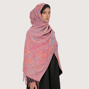 Detail of pink paisley jacquard scarf with fringe, wrapped around head and shoulders