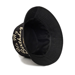 Black cotton bucket hat with gold 'It's My Birthday' print shown from a side angle