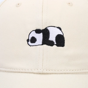 Close-up of cute panda embroidery on beige cotton twill baseball cap fabric