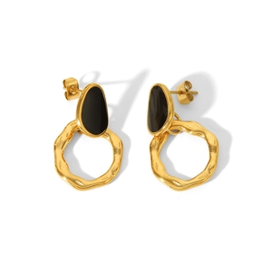 Detail of bohemian gold earrings featuring black drip oil enamel on wavy geometric rings