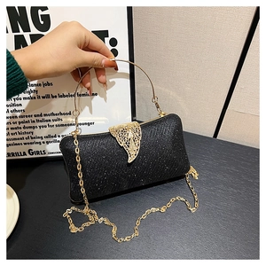 Black glitter evening bag featuring a gold ring handle and hollow leaf clasp detail