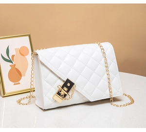 Close-up of white quilted crossbody bag with gold chain strap and elegant square lock