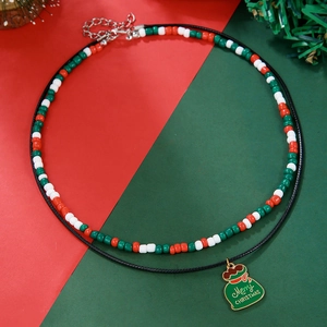 Close-up of red and green bead necklace with a Merry Christmas lucky bag pendant