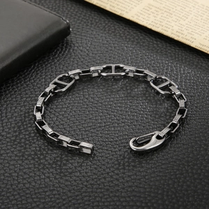 Detail of gunmetal grey oval link bracelet with secure lobster clasp on leather background