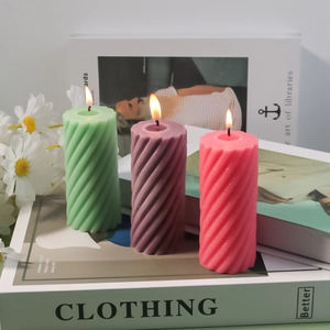 Detail of spiral textured pillar candles in green, purple, and pink on books