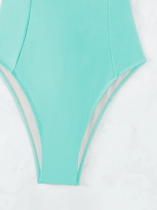 Detailed view of mint green one-piece swimsuit fabric with high-cut leg and double stitching