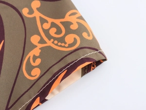 Detailed close-up of woven fabric showing floral plant patterns and sewing stitches