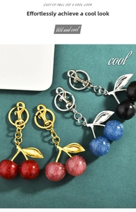 Close-up of glitter cherry keychains in red, pink, blue, and black with metal hooks
